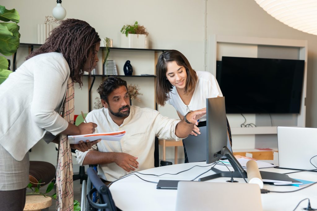 A diverse group of professionals collaborating around a conference table with 'Significance of PR' on a presentation screen